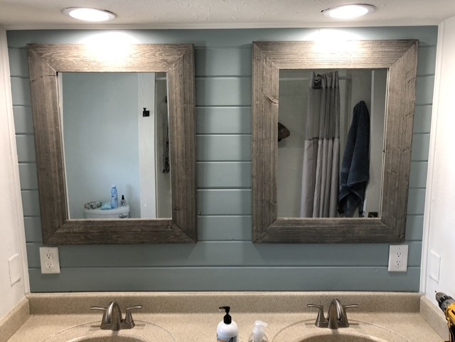 Double bathroom vanity with two square wooden-framed mirrors above two sinks, soap dispensers on countertop, and blue-grey shiplap wall behind.